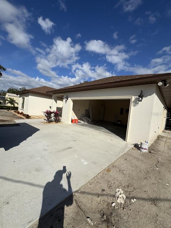 A view of a house exterior featuring a concrete driveway and an open garage — 1911 SW 7TH AVENUE, OKEECHOBEE, FL