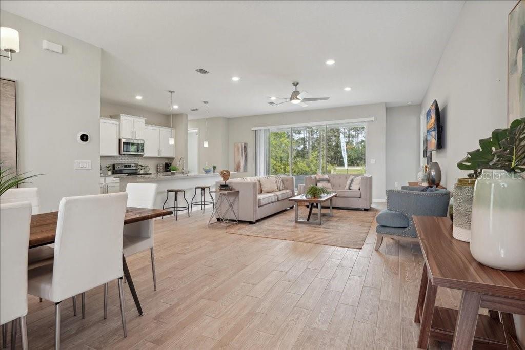 An open-concept living area features a kitchen, dining space, and living room with wood-look flooring — 90 LUTHER DRIVE, PALM COAST, FL