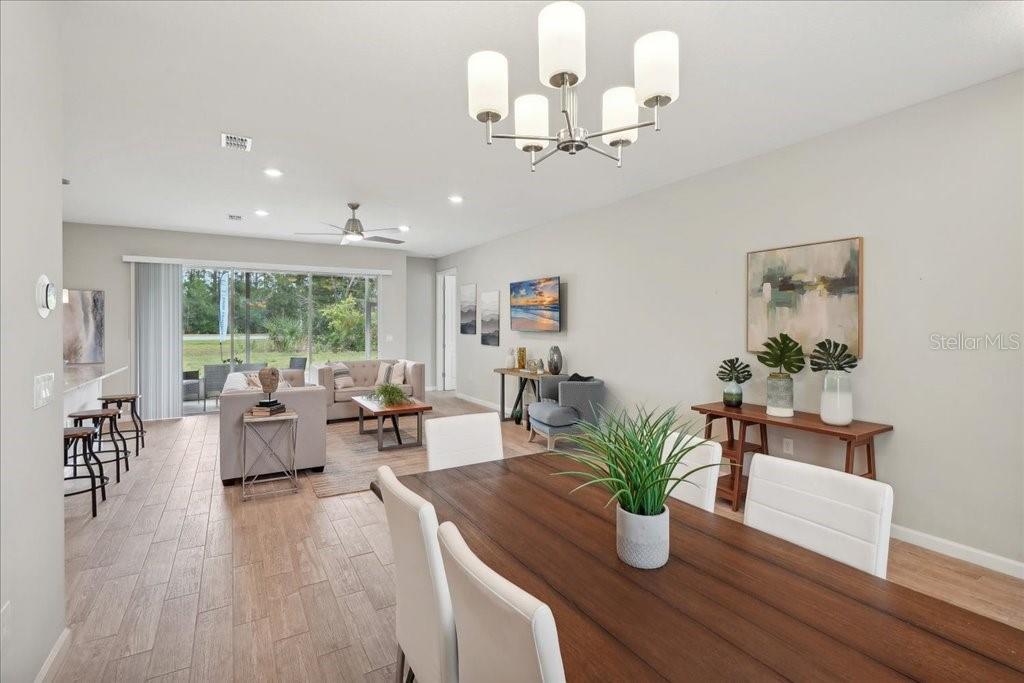 An open-concept living and dining area features light wood-look tile flooring and a modern chandelier — 90 LUTHER DRIVE, PALM COAST, FL
