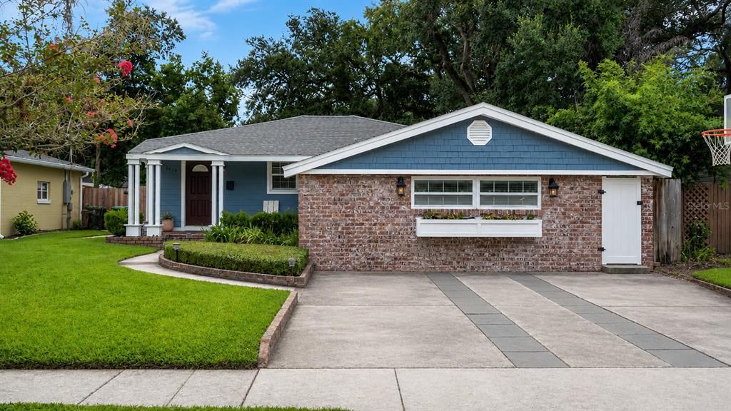 A single-story house features a brick facade, blue siding, a concrete driveway, and a front lawn — 1819 LAKE SUE DRIVE, ORLANDO, FL