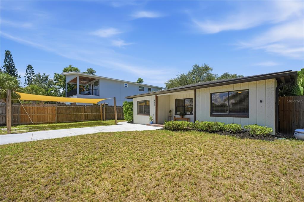 A single-story house with a white exterior, dark trim, and a concrete driveway — 4925 REMINGTON DRIVE, SARASOTA, FL