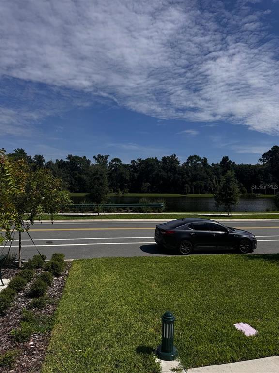 A dark sedan is parked on a road beside a grassy lawn and a lake — 2386 CELEBRATION BOULEVARD, CELEBRATION, FL