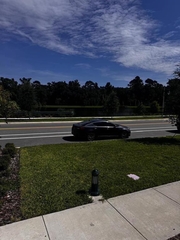 A dark sedan is parked on a road next to a grassy lawn and pond — 2386 CELEBRATION BOULEVARD, CELEBRATION, FL