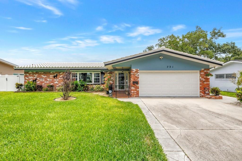 A single-story house with a brick facade, blue gable, and a two-car garage — 731 OBERLIN DRIVE, CLEARWATER, FL