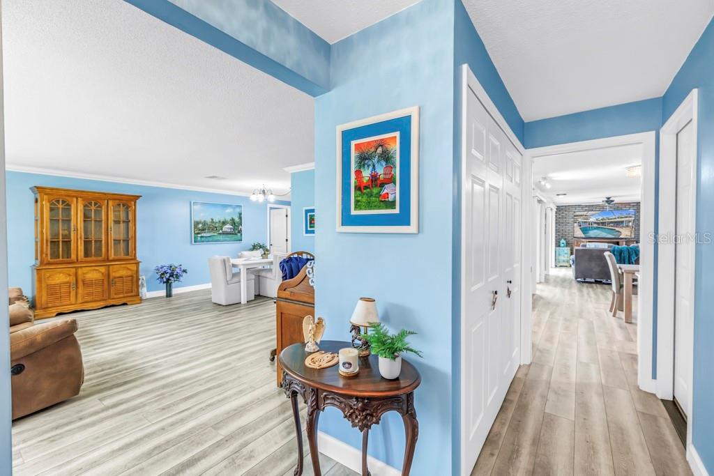 A light blue entryway leads to a dining area and a hallway with wood-look flooring — 731 OBERLIN DRIVE, CLEARWATER, FL