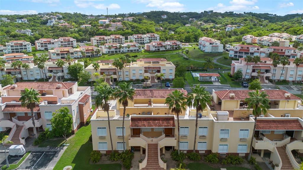 A two-story stucco apartment building with an outdoor staircase and a golf cart parked outside — Harbour Lakes PALMAS DRIVE UNIT 60 D, HUMACAO, PR