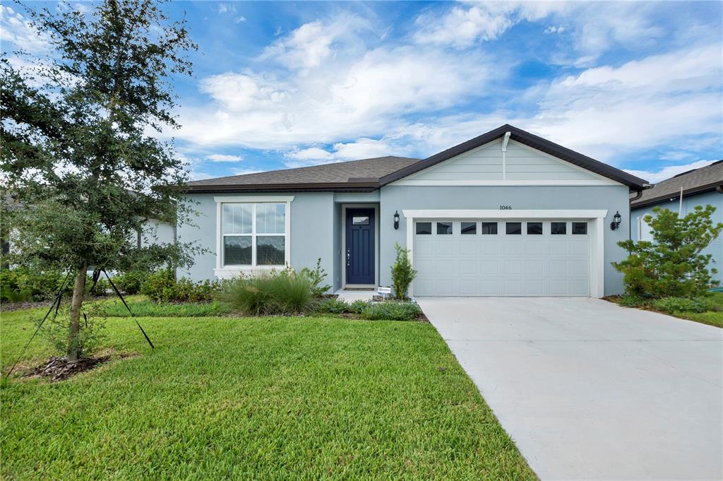 An entryway features light wood-look flooring, a white front door, and a console table — 1046 SILVERLAKE BOULEVARD, LAKE ALFRED, FL