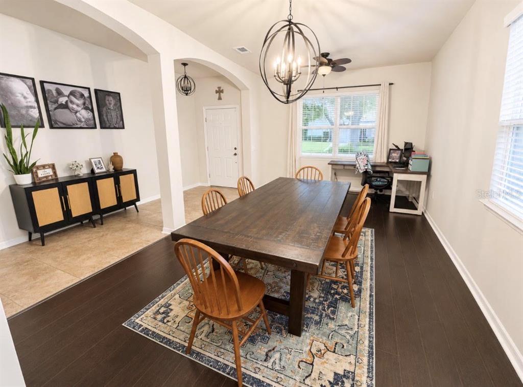 A dining room features a dark wood table, spindle chairs, a patterned rug, and a sideboard — 1518 RHODESWELL LANE, DOVER, FL