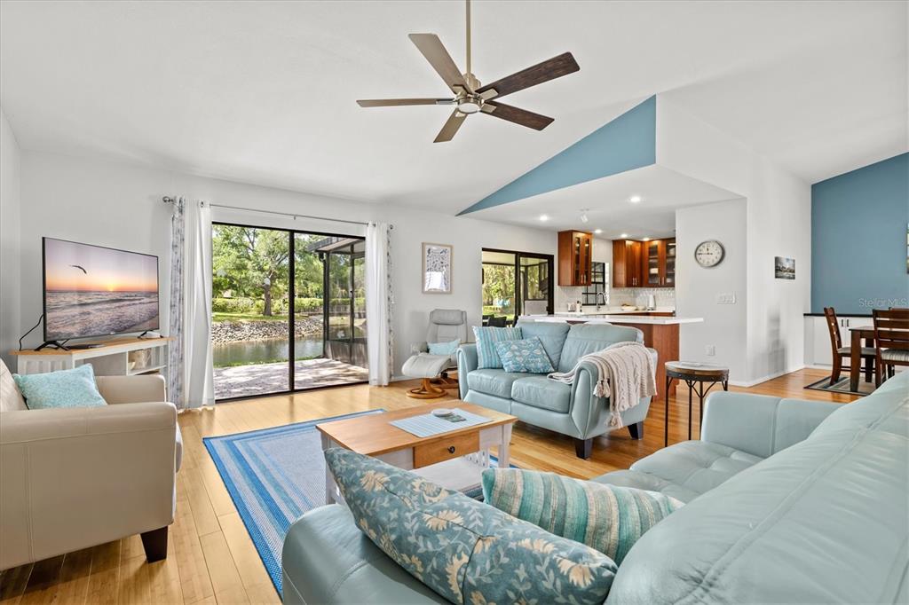 A living room with light blue sofas, a wooden coffee table, and a view of water — 4566 HIDDEN VIEW PLACE UNIT 7, SARASOTA, FL