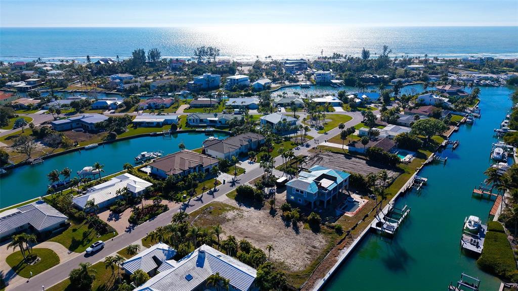 An aerial view shows waterfront homes along canals leading to the ocean — 721 EMERALD HARBOR DRIVE, LONGBOAT KEY, FL