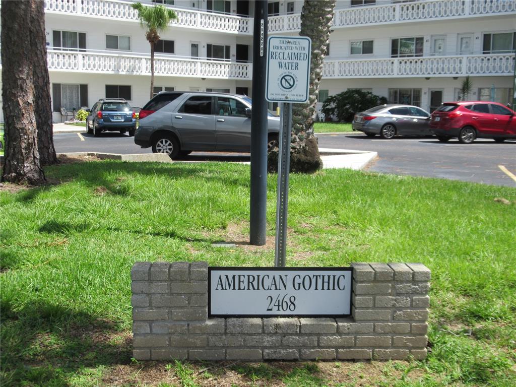 A brick sign labeled American Gothic 2468 stands in front of a multi-story apartment building — 2468 FLORENTINE WAY UNIT 30, CLEARWATER, FL