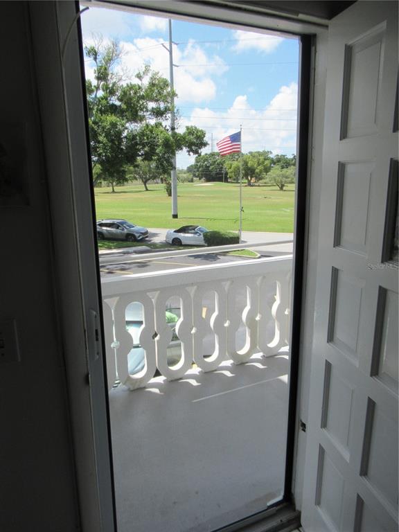 A view from a doorway looking out onto a balcony overlooking a golf course — 2468 FLORENTINE WAY UNIT 30, CLEARWATER, FL