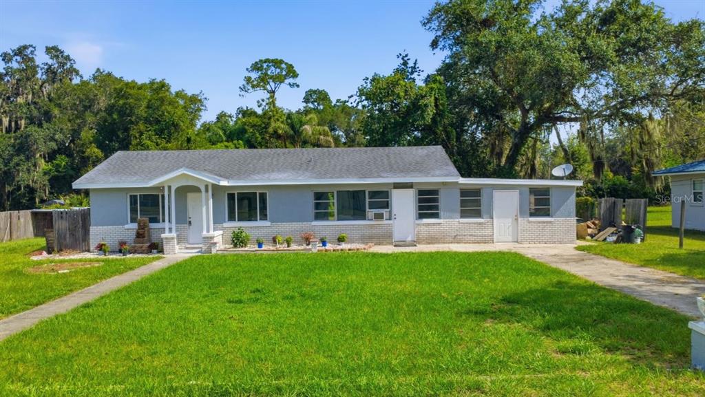 A single-story house with a gray exterior, brick base, and a concrete driveway — 8 SMYRNA DRIVE, DEBARY, FL