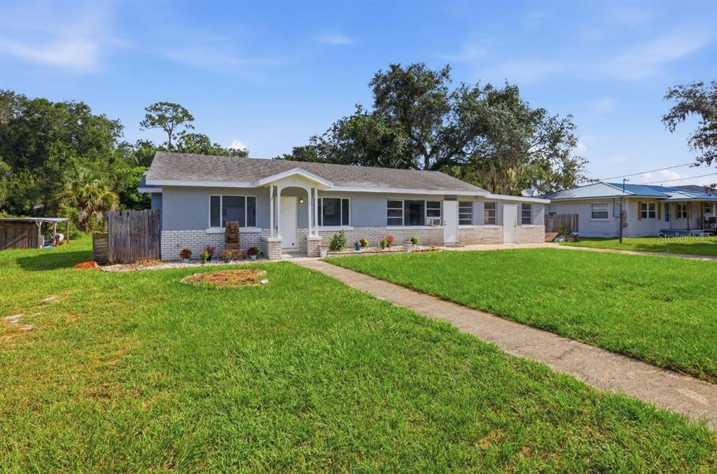A kitchen features white upper cabinets, gray lower cabinets, stainless steel appliances, and wood-look flooring — 8 SMYRNA DRIVE, DEBARY, FL