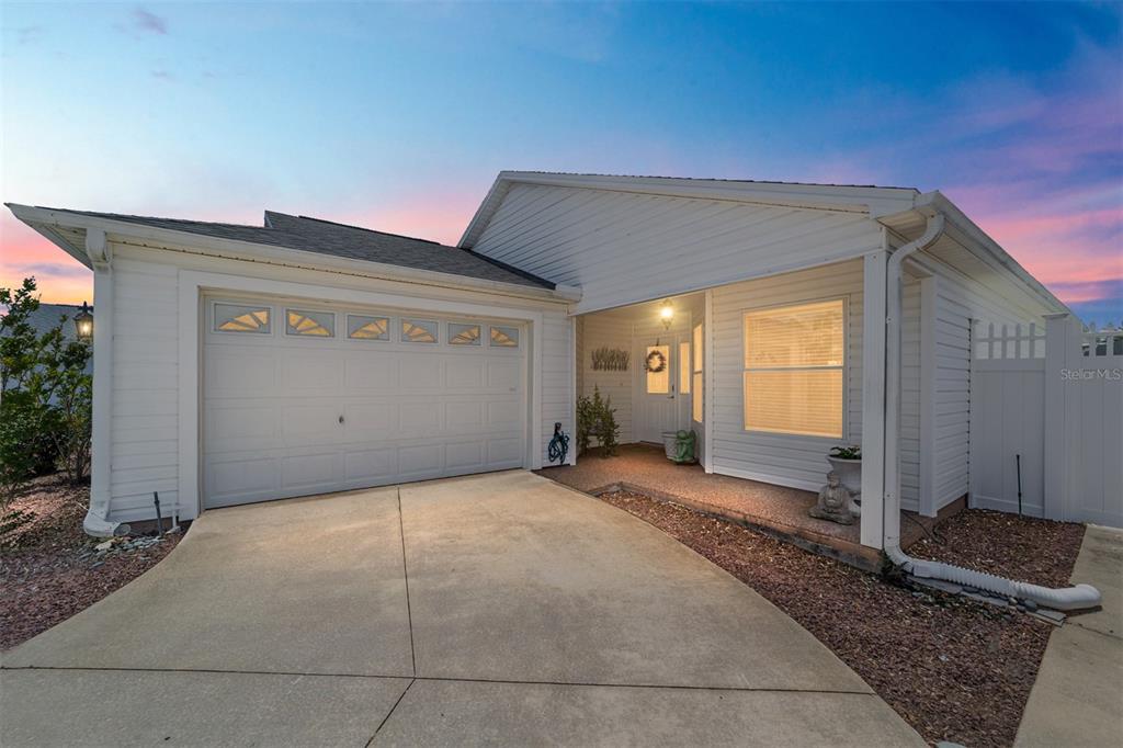 A screened-in patio features a dining set, gravel landscaping, and a white privacy fence — 418 FLOSSMOOR COURT, THE VILLAGES, FL