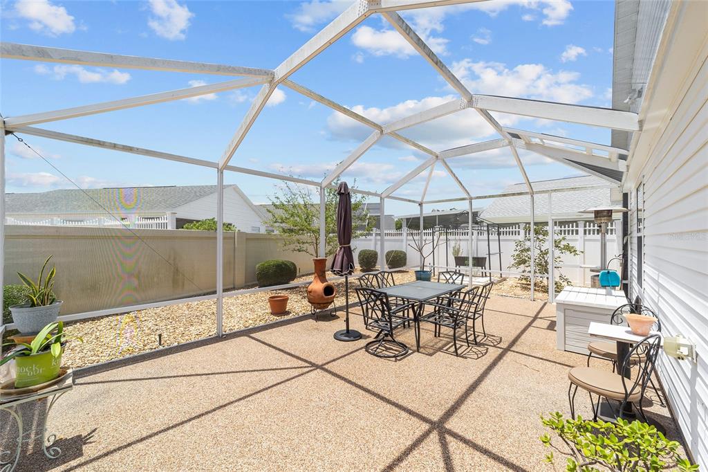 A white single-story house with a garage, concrete driveway, and a white privacy fence — 418 FLOSSMOOR COURT, THE VILLAGES, FL