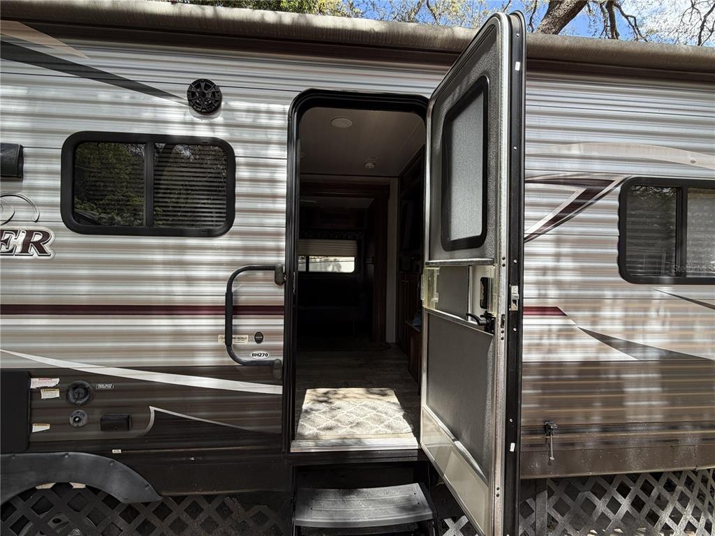 The exterior of a travel trailer features an open door, a window, and a speaker — 3000 CLARCONA ROAD UNIT 743, APOPKA, FL