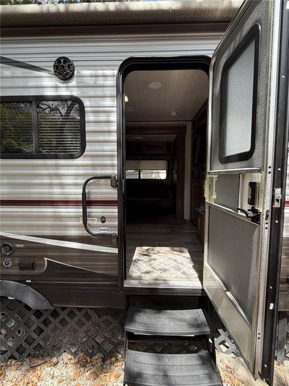 The exterior of a travel trailer features an open door, steps, and a side window — 3000 CLARCONA ROAD UNIT 743, APOPKA, FL