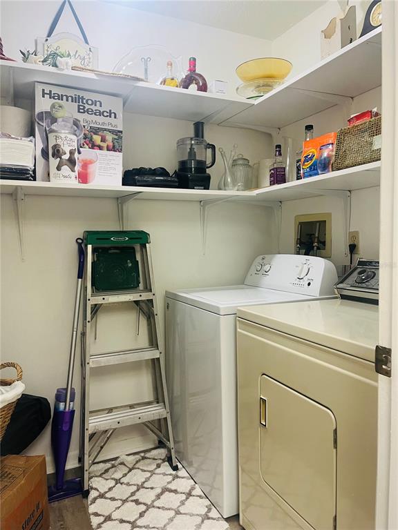 A kitchen features white cabinets, a stainless steel sink, and a pass-through window to the living area — 2583 COUNTRYSIDE BOULEVARD UNIT 3201, CLEARWATER, FL