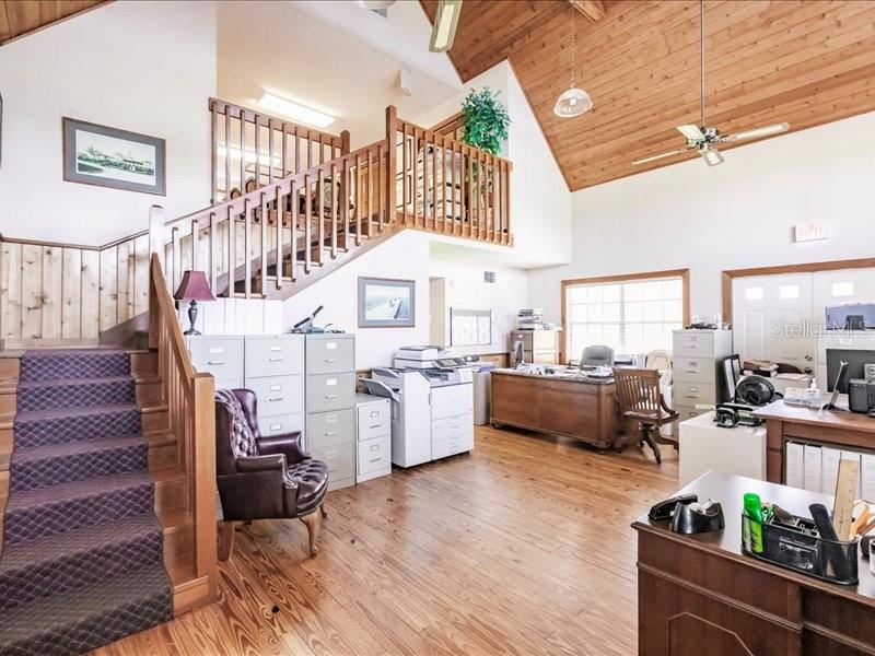This office space features a wooden vaulted ceiling, a staircase, and a loft area — 13075 SR-64 E, BRADENTON, FL