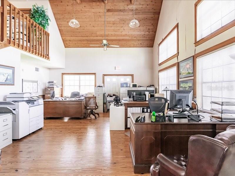 A spacious office features a high wood-paneled ceiling, multiple desks, and large windows — 13075 SR-64 E, BRADENTON, FL