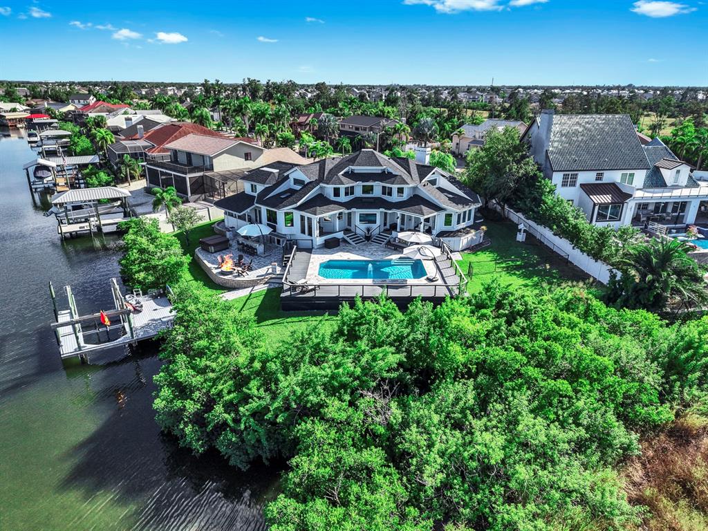 An aerial view shows a waterfront house with a swimming pool, deck, and private dock — 945 BUNKER VIEW DRIVE, APOLLO BEACH, FL