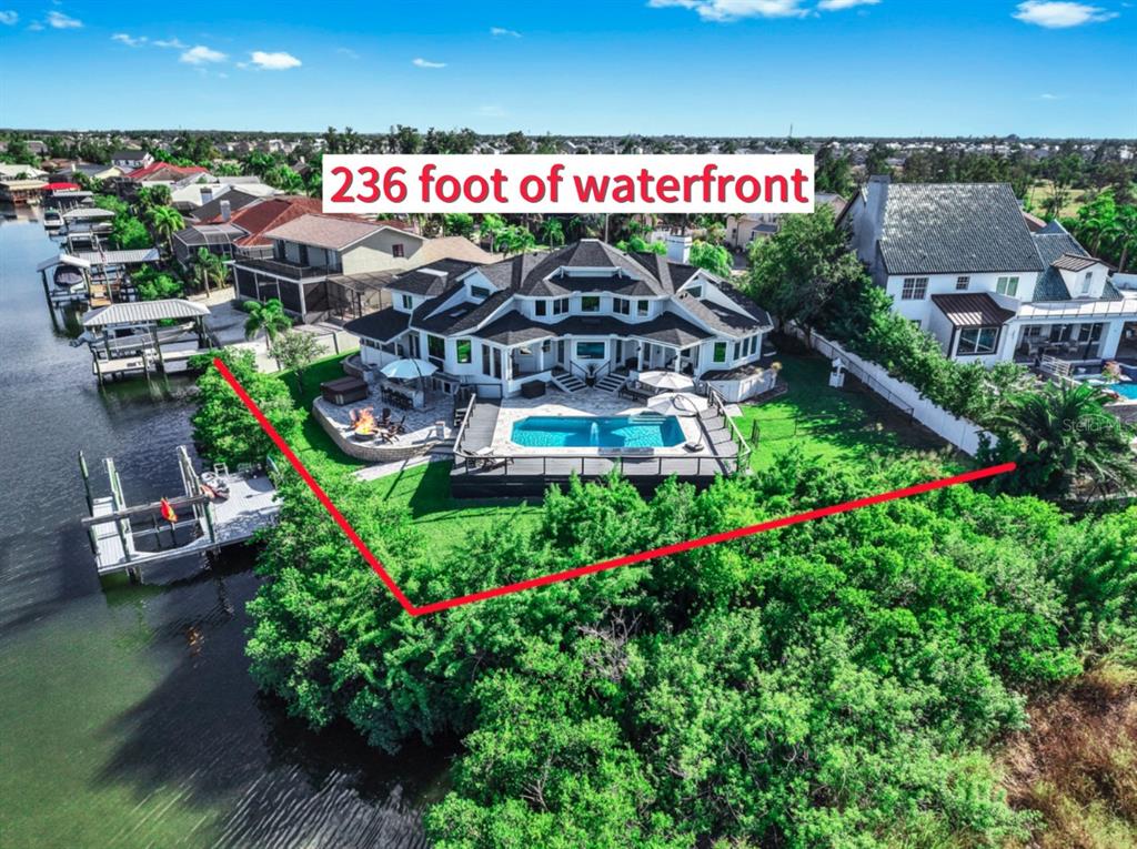 An aerial view shows a waterfront house with a pool, deck, and private boat dock — 945 BUNKER VIEW DRIVE, APOLLO BEACH, FL