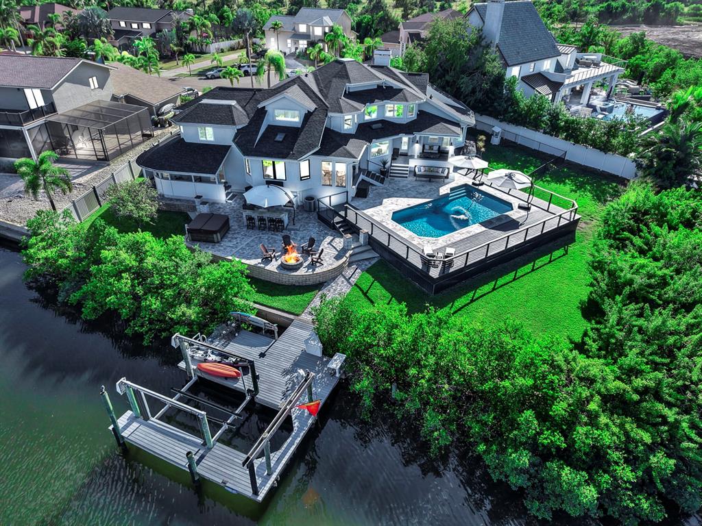 An aerial view of a waterfront house with a pool, deck, fire pit, and boat dock — 945 BUNKER VIEW DRIVE, APOLLO BEACH, FL