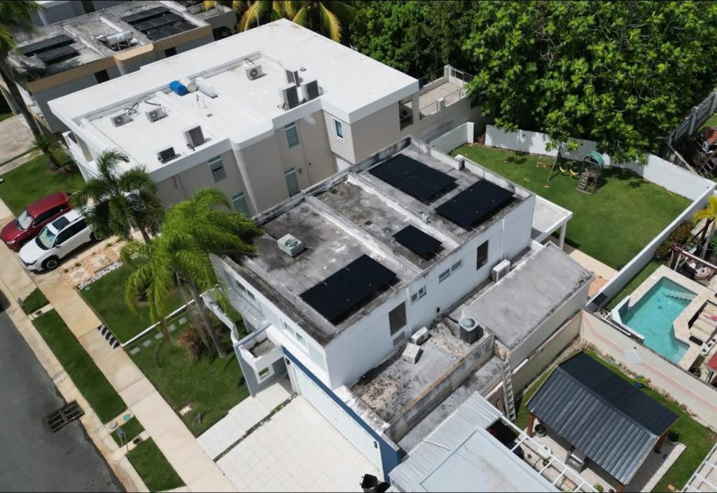 An aerial view of a two-story house with solar panels on a flat concrete roof — Calle 10 S7, TOA ALTA, PR