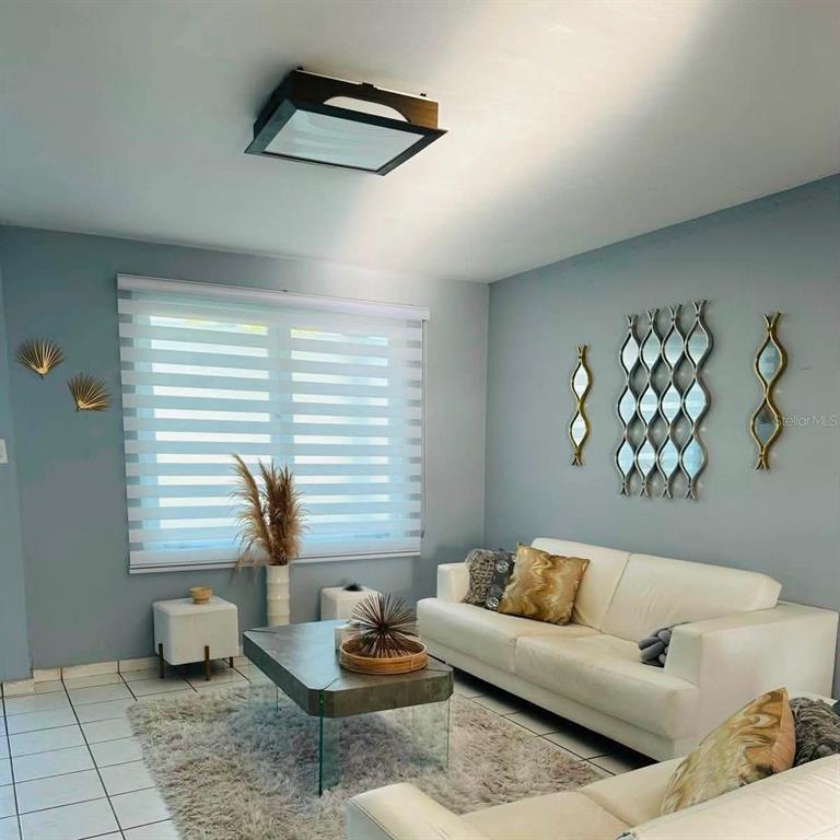 A living room features a white sofa, a glass coffee table, and decorative wall mirrors — Calle 10 S7, TOA ALTA, PR
