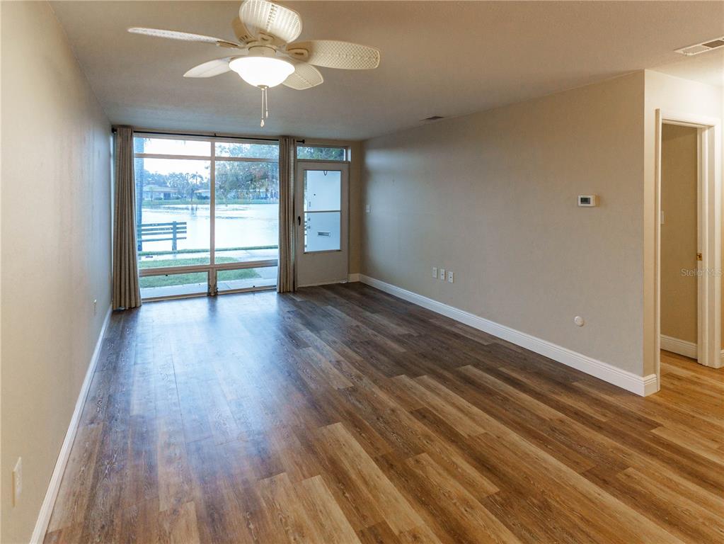 A kitchen features wood-grain cabinets, a white refrigerator, a black stove, and light-colored flooring — 4318 TAHITIAN GARDENS CIRCLE UNIT F, HOLIDAY, FL