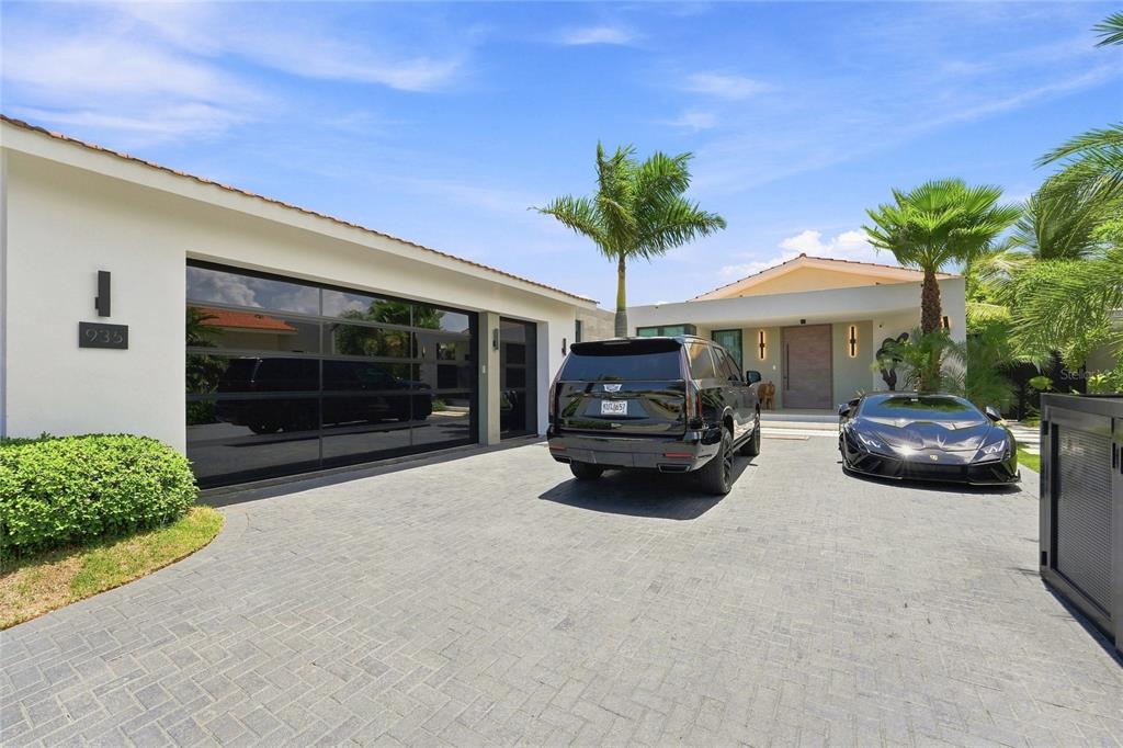 A modern house exterior features a paved driveway, a black SUV, and a sports car — 935 ISLA NORTE, DORADO, PR