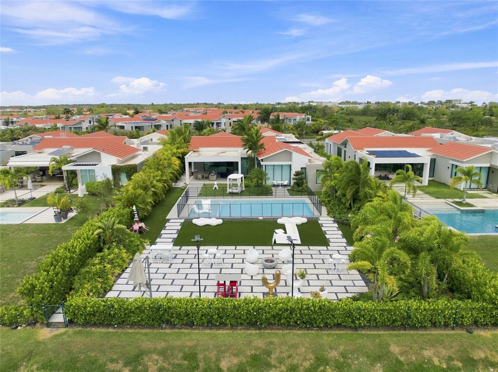 An aerial view of a backyard featuring a swimming pool, patio, and landscaped lawn — 935 ISLA NORTE, DORADO, PR