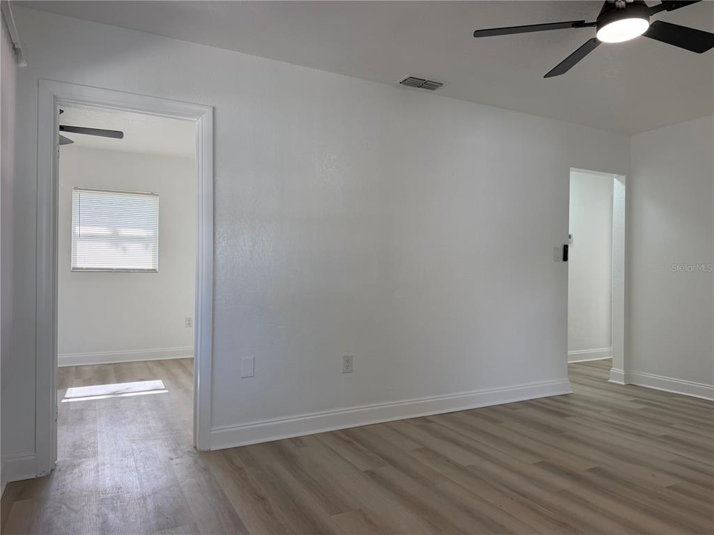 A room with white walls, light wood-look flooring, and two doorways leading to other spaces — 1705 E BIRD STREET, TAMPA, FL