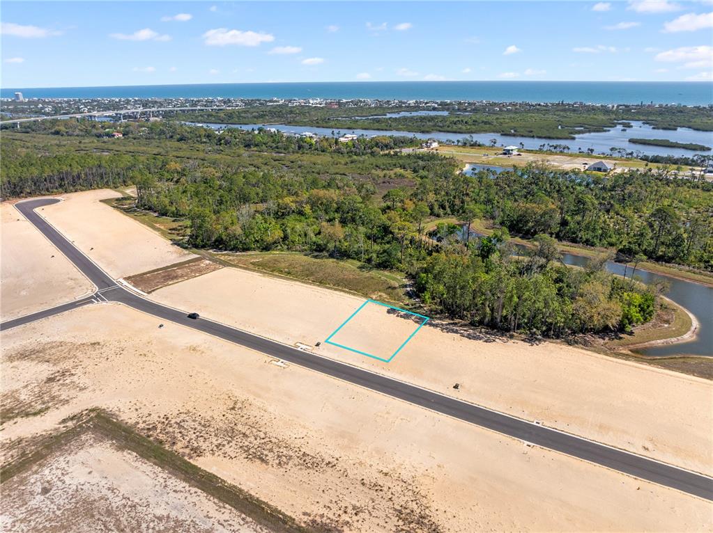 An aerial view shows a vacant residential lot outlined in blue along a paved road — 210 STILLWATER DRIVE, FLAGLER BEACH, FL