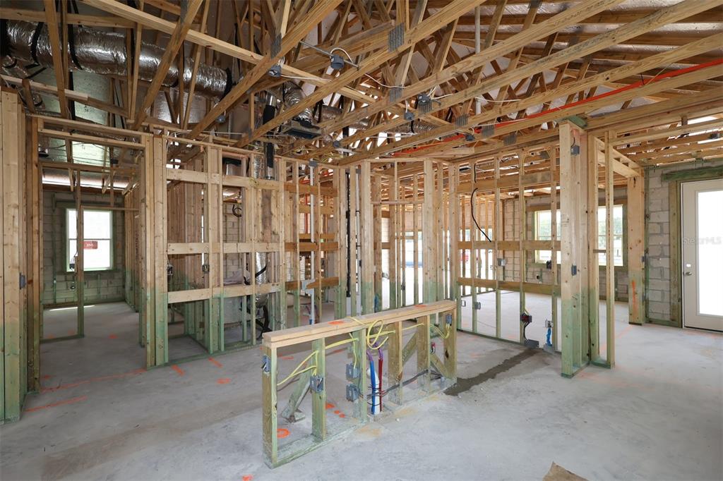 An interior view of a house under construction showing wood framing, exposed ductwork, and concrete — 2867 SWEETGRASS LANE, ZELLWOOD, FL