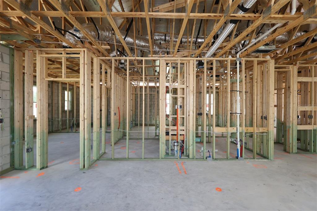 An interior view of a building under construction featuring exposed wood framing and concrete floors — 2867 SWEETGRASS LANE, ZELLWOOD, FL