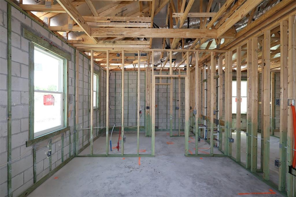 An unfinished room under construction with concrete block walls, exposed wood framing, and visible plumbing — 2867 SWEETGRASS LANE, ZELLWOOD, FL