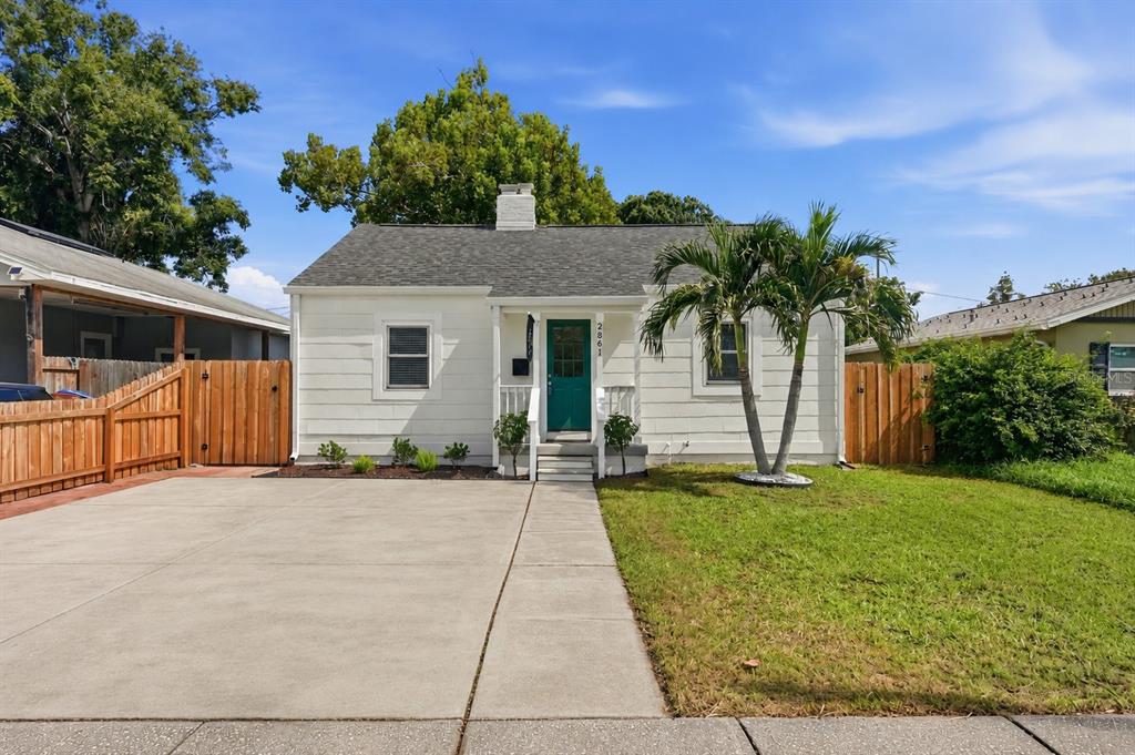 A white house exterior features a front porch with stairs and a neighborhood flag — 2861 17TH AVENUE N, ST PETERSBURG, FL