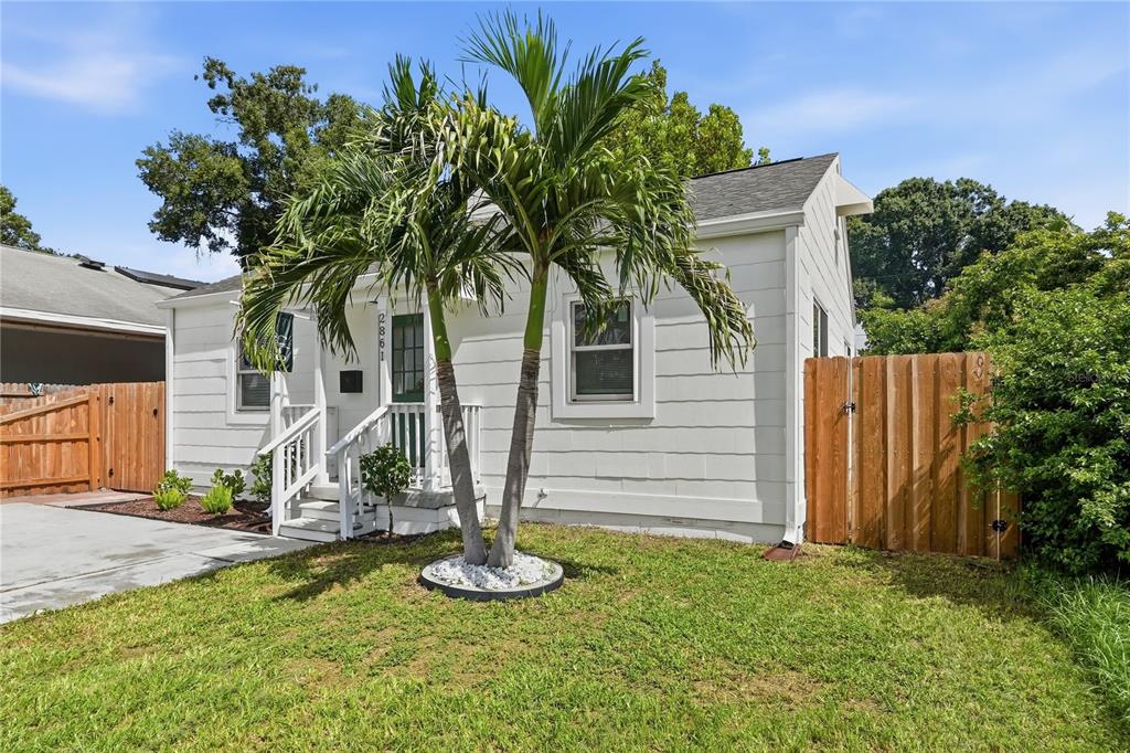 A white house with a palm tree in the front yard and a wooden fence — 2861 17TH AVENUE N, ST PETERSBURG, FL