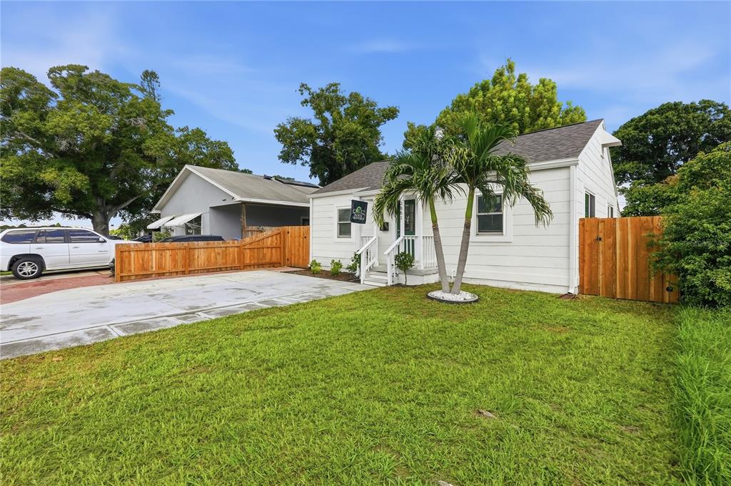 A white house with a palm tree in the front yard and a wooden fence — 2861 17TH AVENUE N, ST PETERSBURG, FL