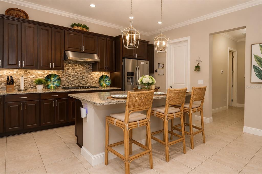 A covered brick porch features yellow walls, arched windows, patio furniture, and a wooden door — 15149 CANOE PLACE, WINTER GARDEN, FL