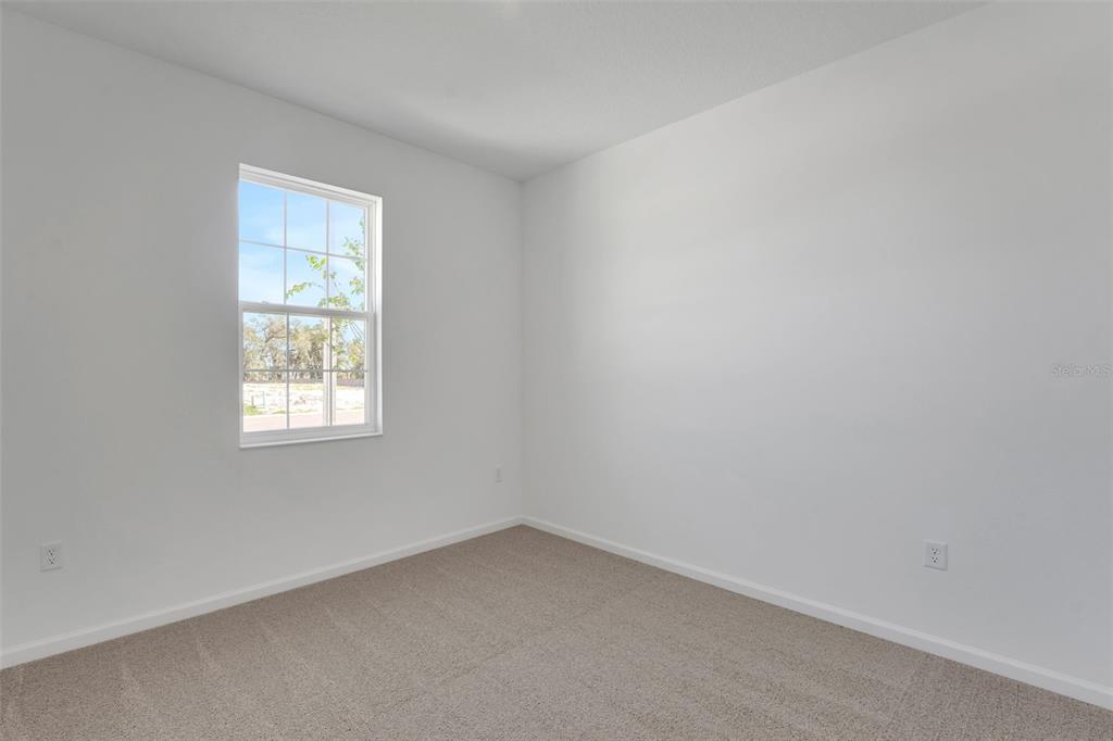An empty bedroom with white walls, beige carpeting, and a single window — 300 MEREDITH BOULEVARD, WINTER HAVEN, FL
