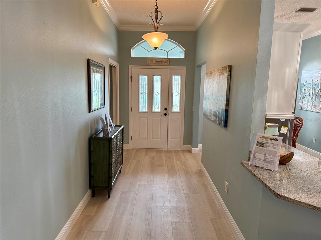 A living room features light blue walls, tile flooring, a ceiling fan, and a television — 2837 GRANT WAY, THE VILLAGES, FL