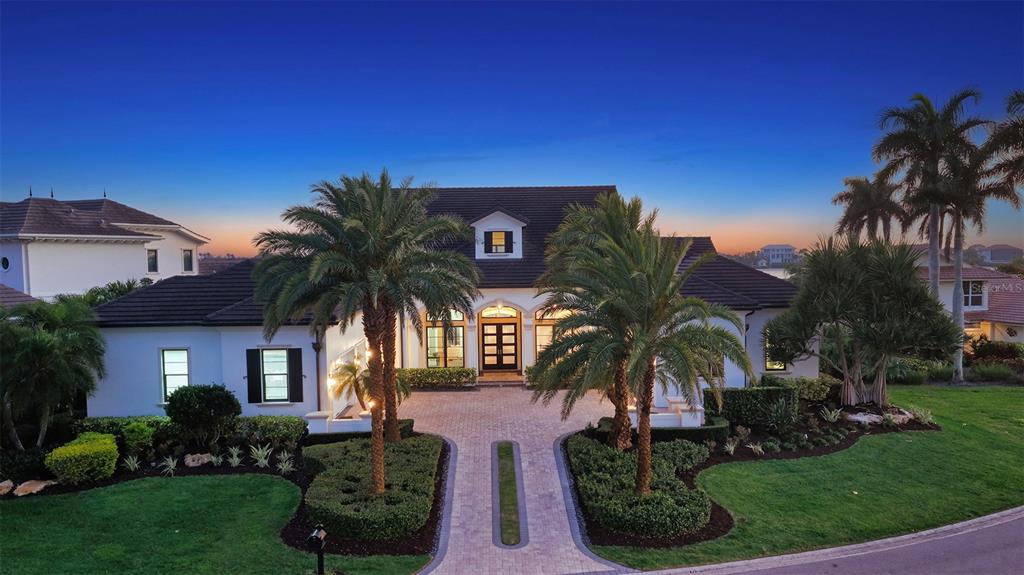 A single-story house with a paved driveway, palm trees, and a dark tiled roof — 313 LOOKOUT POINT DRIVE, OSPREY, FL