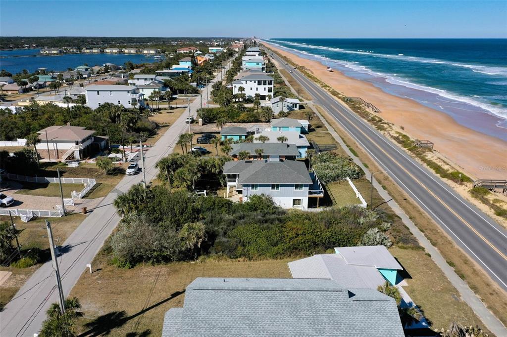 An aerial view shows a coastal road running alongside a beach with eroded dunes — 1922 N CENTRAL AVENUE, FLAGLER BEACH, FL