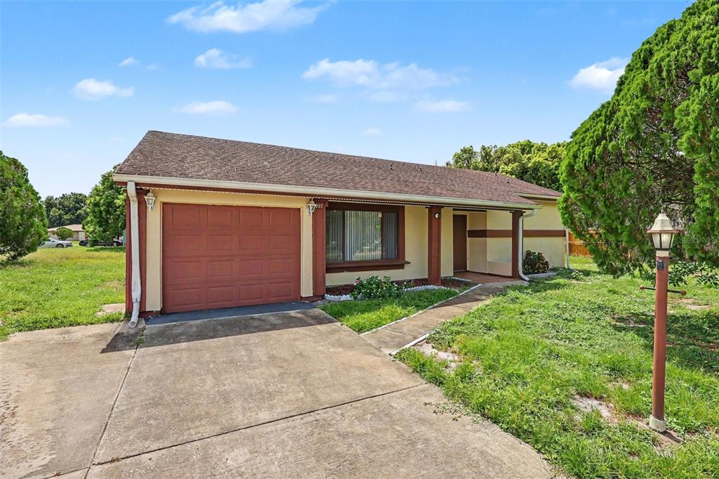A single-story house with a brown garage door, a front porch, and a concrete driveway — 997 MARIPOSA DRIVE NE, PALM BAY, FL