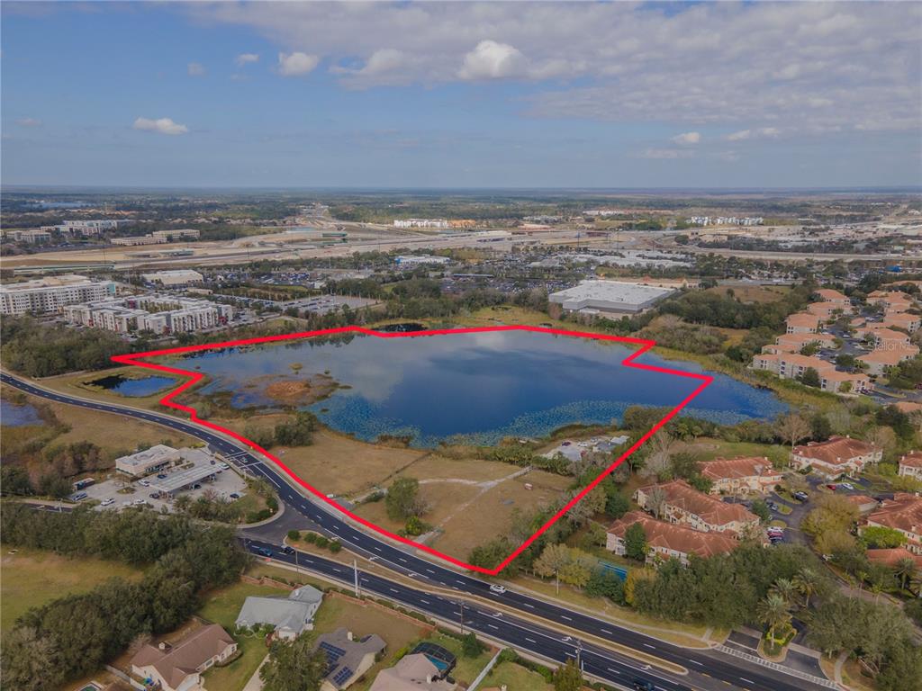 An aerial view shows a large lake surrounded by residential and commercial properties — 4950 COUNTY ROAD 46A, SANFORD, FL