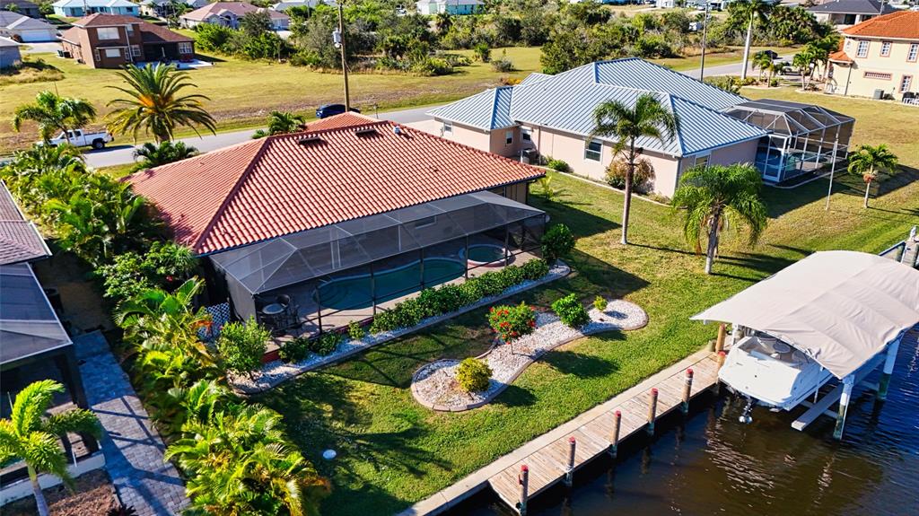 An aerial view of a waterfront house with a pool, screened lanai, and boat dock — 15564 RUSTON CIRCLE, PORT CHARLOTTE, FL