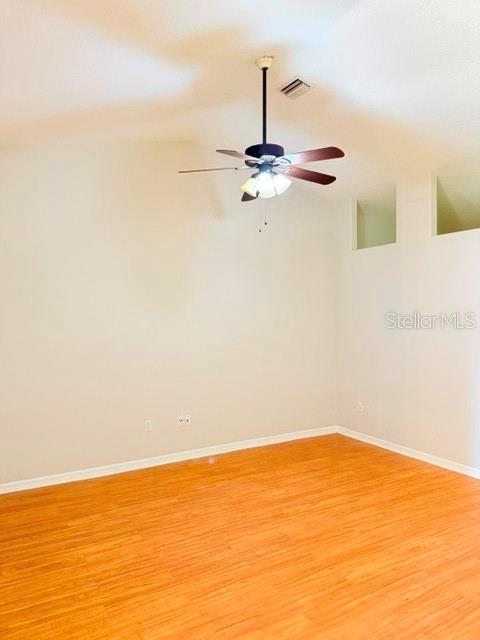 An empty room features light-colored walls, wood-look flooring, and a ceiling fan with lights — 5 PONTIAC LANE UNIT B, PALM COAST, FL